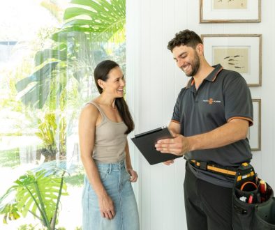 Licensed smoke alarm installer upgrading alarms in a Gold Coast home to meet 2027 Queensland legislation